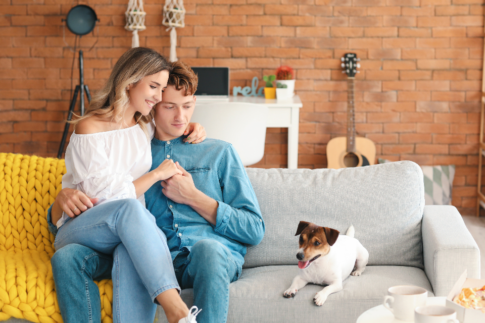 Young couple on sofa with dog