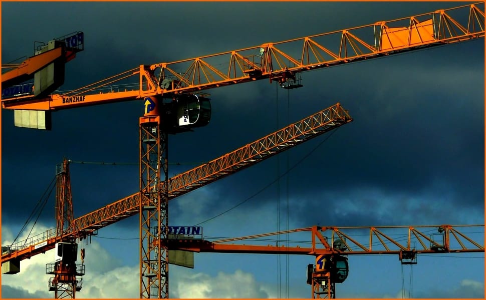 Tower cranes against stormy sky