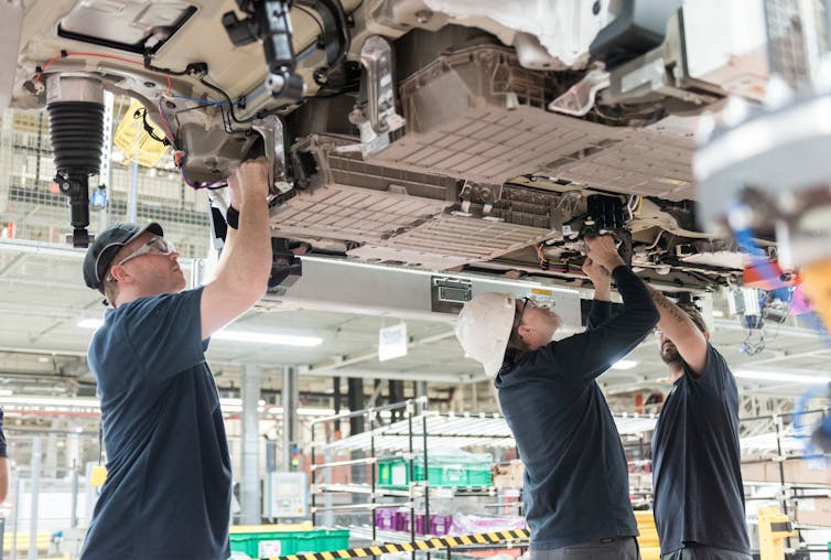 Workers install battery packs in a BMW X5 in South Carolina. A new battery plant under construction nearby will supply BMW factories. BMW