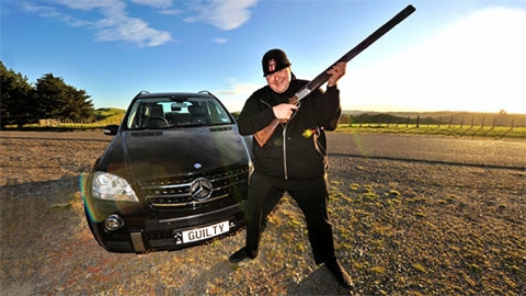 Kim Dotcom posing in front of his NZ registered Mercedes with numberplat Guilty