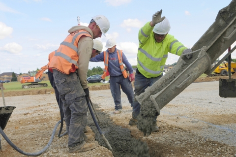 Builders pouring concrete